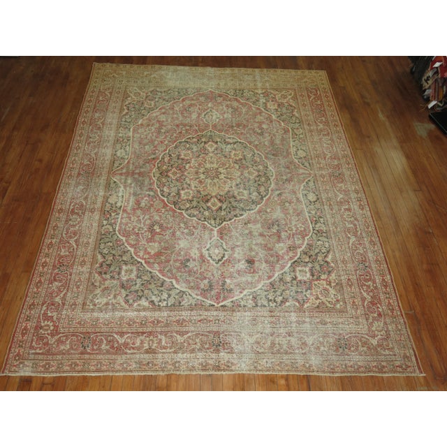An early 20th Century room size Persian Tabriz rug with a classic formal design on a soft red field. Professionally...