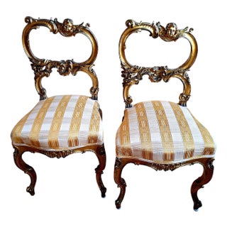 A Pair of Rococo-Style, Gilded and Putti-Adorned Side Chairs For Sale