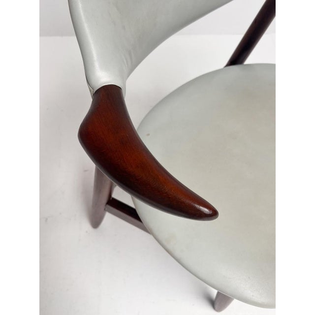 This typical vintage cowhorn chair is recognizable by its armrests shaped like a cowhorn. This distinctive wooden chair is...