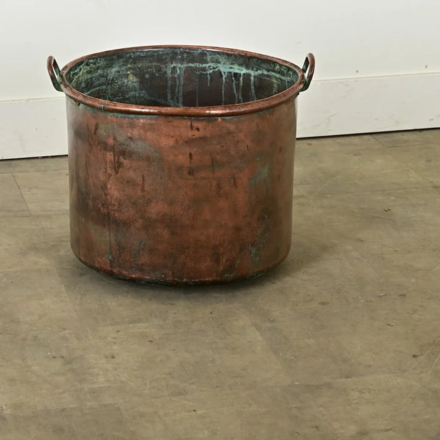 Dimensions: 16 ½” H x 20 ¼” W x 19” D A substantial antique English copper pot, with two narrow handles at the rim, from...