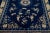 This luxurious antique Peking Chinese hand knotted wool rug features a navy blue field adorned with a designed frame and...