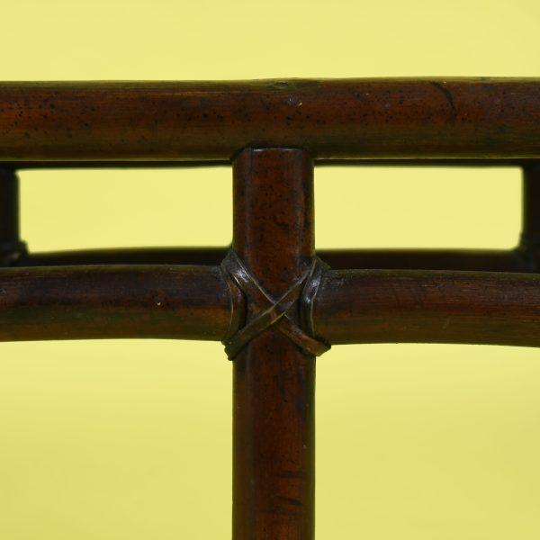 A large rattan bench with dramatic wing sides, its sweeping arms giving the woven frame a sculptural, sheltering presence....
