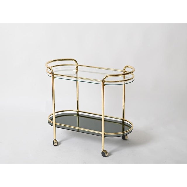 Stunning Italian mid-century bar cart entirely made of tubular gilt metal, completed with a deep green mirrored lower...