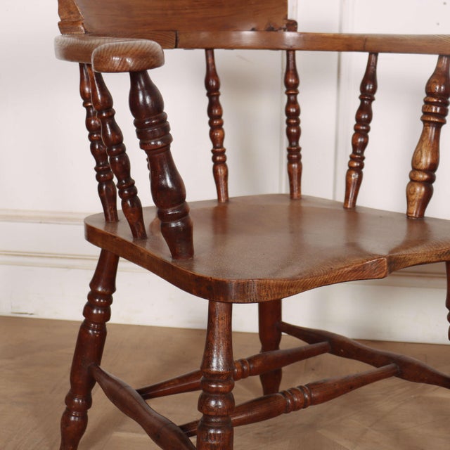 Interesting pair of 19th century English elm smokers bow arm chairs with a shaped seat front. 1880. Seat height: 18-inches...