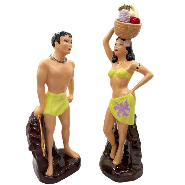 This pair of vintage mid-century ceramic figurines depicts a stylized Polynesian man and woman. Hand-painted with a glossy...