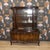 Beautiful dark glass-fronted display cabinet with a base unit on delicate, curved legs. In the style of...