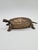 A decorative brass box shaped like a turtle. This piece combines practicality with decorative appeal, making it an...