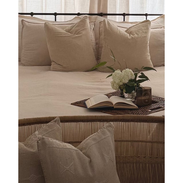 A beautifully handwoven square rattan tray featuring integrated cutout handles and an intricate geometric weave....