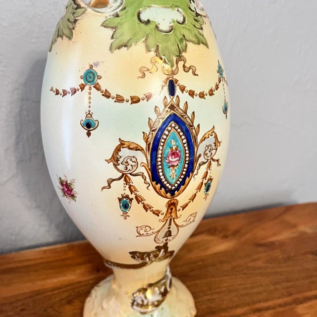 Interesting style vase, having an egg shell color decorated with a spray of flowers picked out in gold. My favorite part...