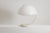 Elio Martinelli. “Serpente” table lamp, made of white-lacquered metal with a white opal methacrylate shade. Iconic model....