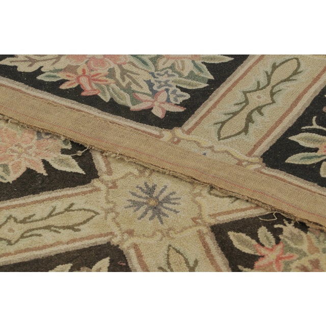 Handmade in wool, this 8x12 antique hooked rug, circa 1920-1929, features an elegant lattice of floral garden panels...
