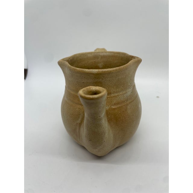 Experience the artistry and functionality of this Cole Pottery handmade teapot, featuring a captivating burn mustard hue....