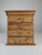 A handcrafted small-scale cabinetry piece constructed from solid pine, dating to the 1940s. The structure is defined by...