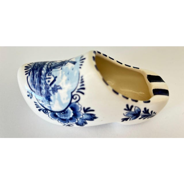 Vintage Delft Blue Ceramic Clog Ashtray, Hand-Painted Windmill Motif, Holland A charming and collectible Delft Blue...
