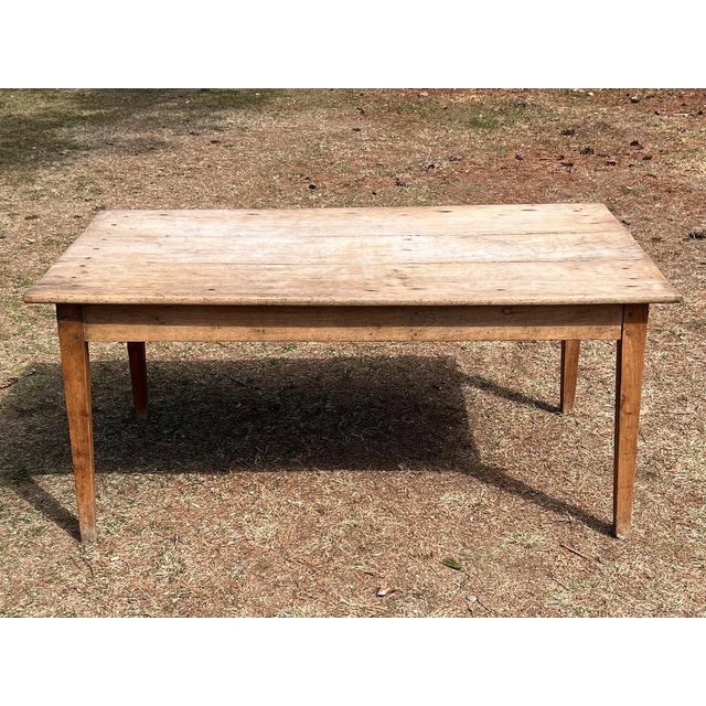 A wonderfully honest early 19th century provincial farmhouse table featuring a beautifully timeworn plank top raised on...
