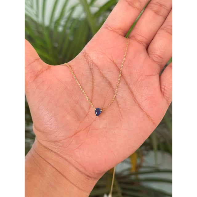 This pendant necklace features a 0.72 carat pear-shaped blue sapphire set in 18K yellow gold. The sapphire measuring...