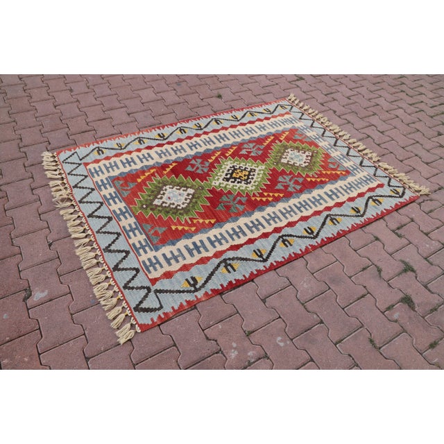 1960s Tribal Red Hand Knotted Kilim Rug Size: 4.3 x 5.7 ft (130 X 173 cm) 51 x 68 inches Color: Red, Baby Blue, Green,...