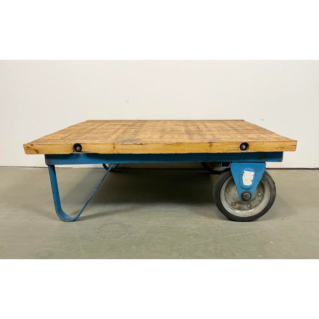 Former pallet truck from a factory now serves as a coffee table. It features a blue iron construction with two original...