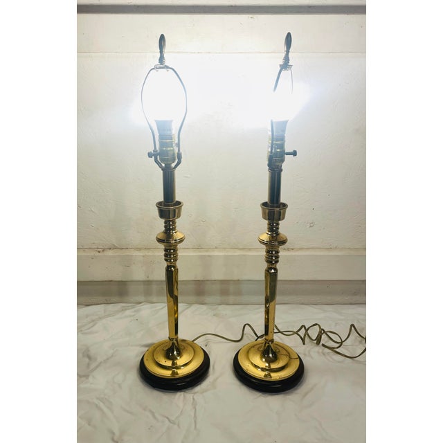 Lovely pair of brass lamps in the form and shape of brass candlesticks. The wonderful pair have Roseart custom shades. One...