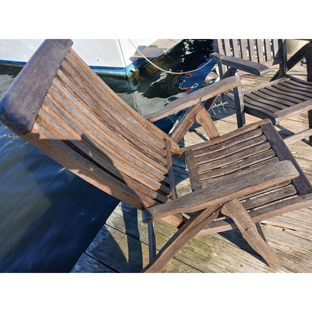 Vintage well-made matching pair of semi-reclining teak arm armchairs. Time and weathered patina that only ocean breezes...