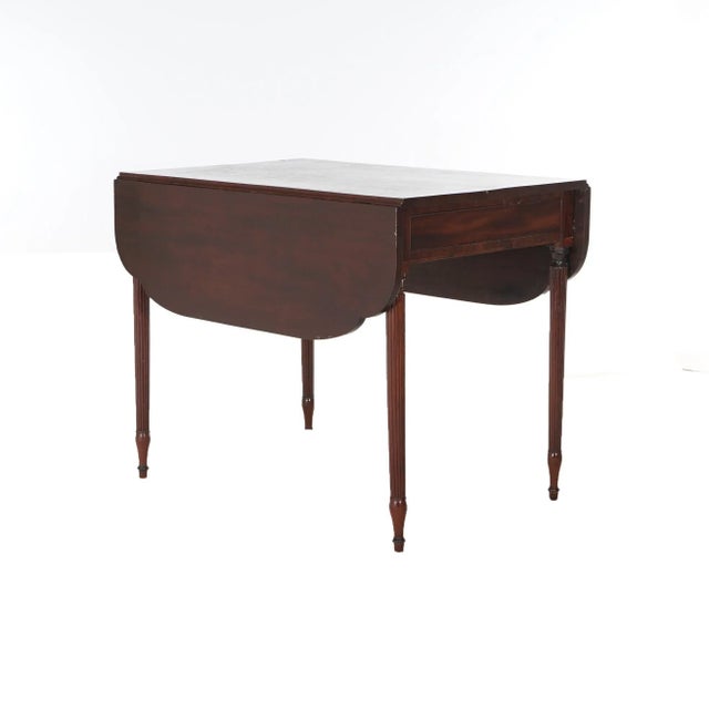 An antique Sheridan Pembroke table offers mahogany construction with drop leaves, raised on reeded legs, c1820 Measures -...