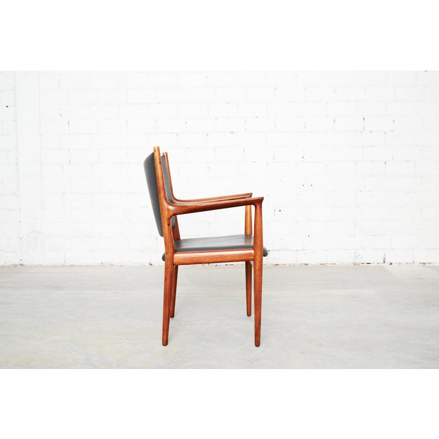 Condition: frame made of solid teak. Seat and backrest upholstered in dark gray faux leather. Two chairs available. hans...