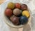 Stone decorative bowl with 12 wood balls in various colors. Vintage Showroom Sample By Sarreid, made in India.