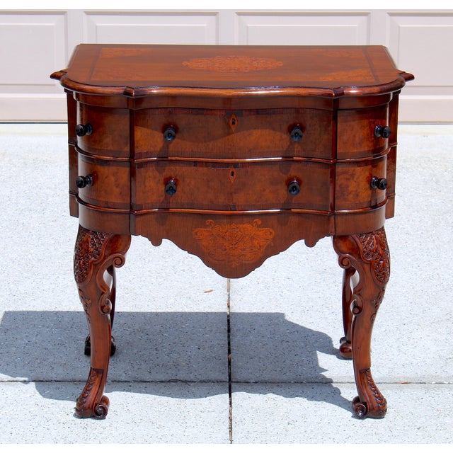 A striking Victorian serpentine chest dating circa 1880, featuring intricate marquetry inlay, elegant curves, and true...