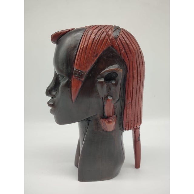 This impressive, hand-carved sculpture of an African head is a prime example of masterful wood carving from the mid-20th...