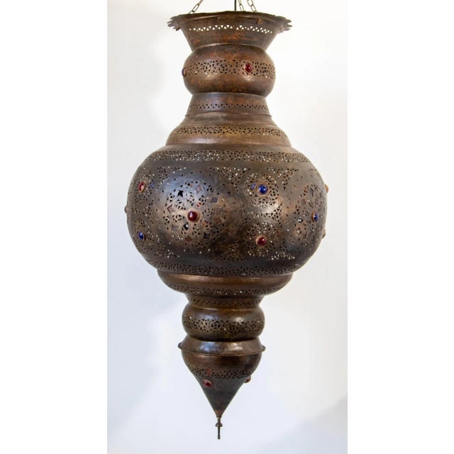 Large Moroccan bronzed patinated pendant chandelier. This large scale Moorish chandelier is delicately hand-hammered and...