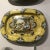 Hand painted ceramic wall plate featuring woman and child by stream in yellow and blue colors. Hand made items may vary in...