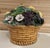 Beautiful vintage majolica basket filled with fruit, vegetables, and flowers surrounded by foliage.