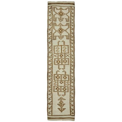 This exquisite runner rug is a rare example of tribal craftsmanship, hand-knotted by the women of the Herki tribe during...