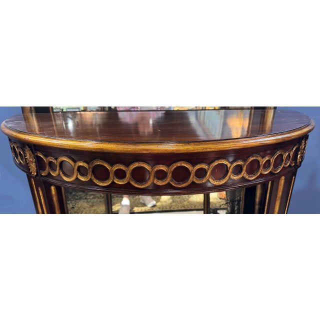 Maitland Smith style Regency demilune console table. Features richly carved details with Louix-XVI tapered legs and gilt...