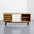 Cansado sideboard with an ash veneer body, opening with two sliding doors covered in black and white laminate and four...