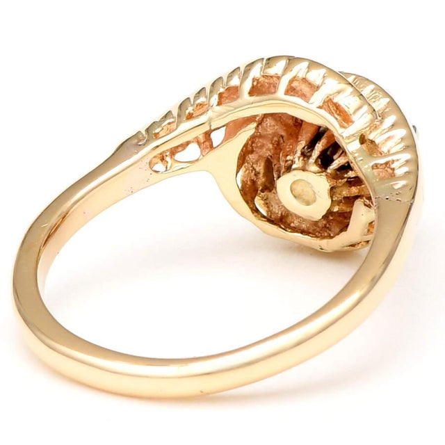 A beautiful round sapphire with deep purple tones graces the top of this enchanting vintage swirl ring. Crafted from 14K...