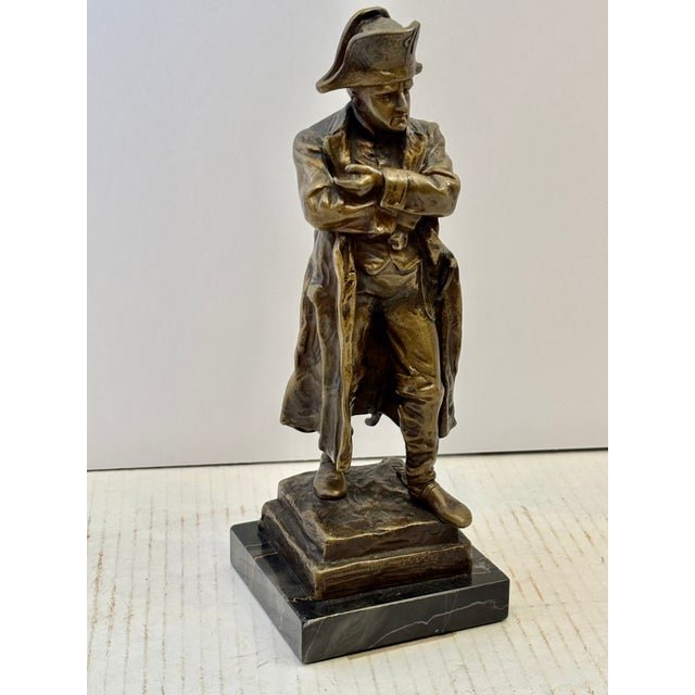 Antique cast bronze sculpture depicting French Emperor Napoleon Bonaparte standing in his iconic crossed-arms pose,...