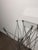 Distinctive Bjart folding pedestal table featuring an architectural metal rod construction and a clear glass top. The...