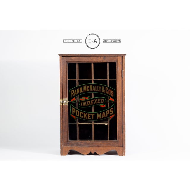 This oak display cabinet was manufactured for Rand McNally & Co. to hold and organize their line of indexed pocket maps....