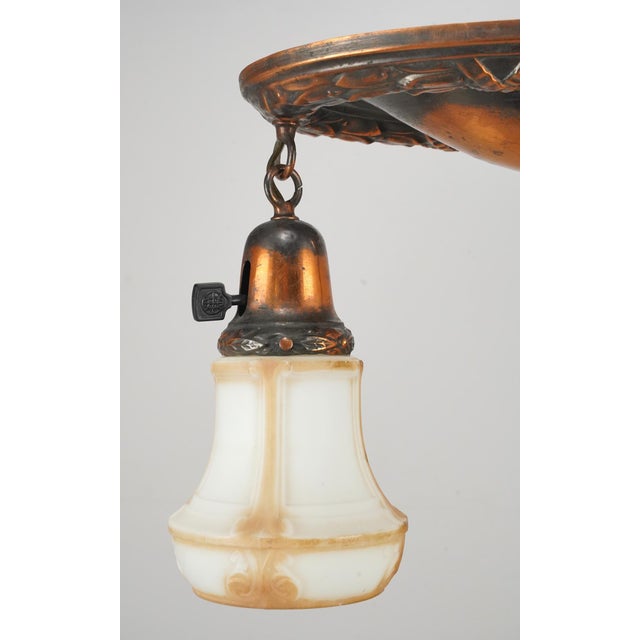 Early 20th century Victorian semi flush mount ceiling light with two white and tan shades suspended downward from a...