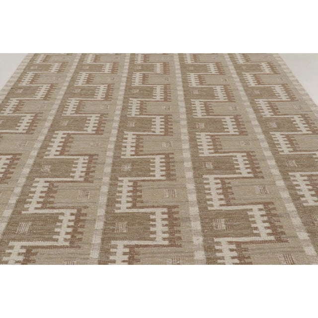Handwoven in wool, this 9x12 Scandinavian rug presents an architectural geometric design in soft beige and ivory. Layered...