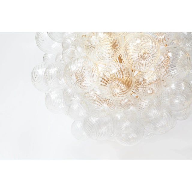Talia Large Chandelier in Gild and Clear Swirled Glass Designer: Julie Neill Canopy: 5" Round Mounting: Chain Shade...