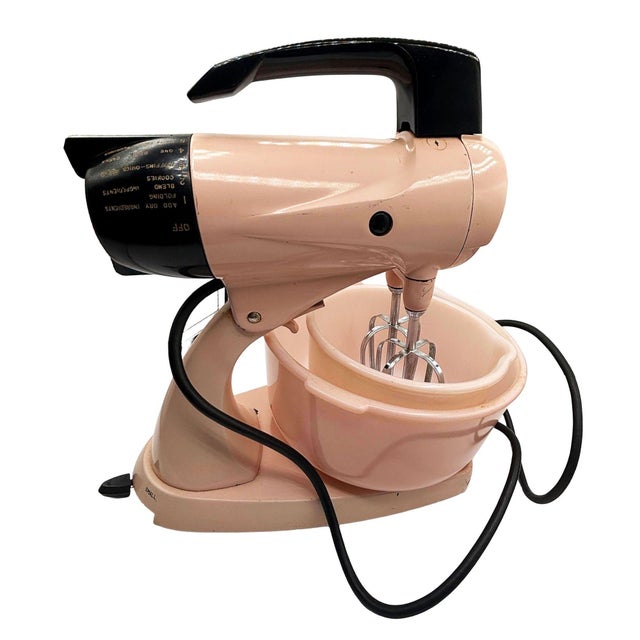 This vintage 1950 Sunbeam Mixmaster Model 12 with 12-speed settings, featuring a distinctive pastel pink finish with...