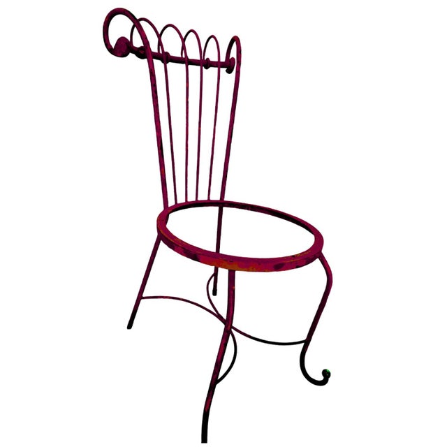 A fire engine red painted iron scroll back chair that could be used in the interior or the outdoors, This chair has no...