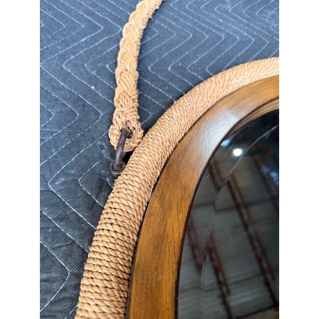 This coastal-inspired round mirror features a warm natural wood frame wrapped with a braided natural rope border for added...