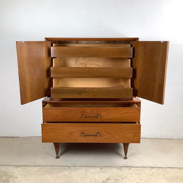 Clean lines, warm wood, and thoughtful storage make this mid-century highboy an effortless upgrade to any room. The upper...