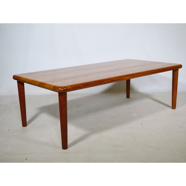 Coffee table by Grete Jalk for Glostrup from the 1960s, featuring a rectangular teak tabletop, softly rounded edges, and...