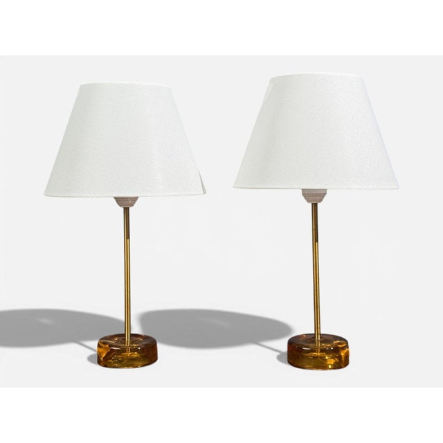 Nybro Armaturfabrik, Swedish Mid-Century Modern, Table Lamps, Amber Glass, Brass, Sweden, 1970s A pair of amber glass,...