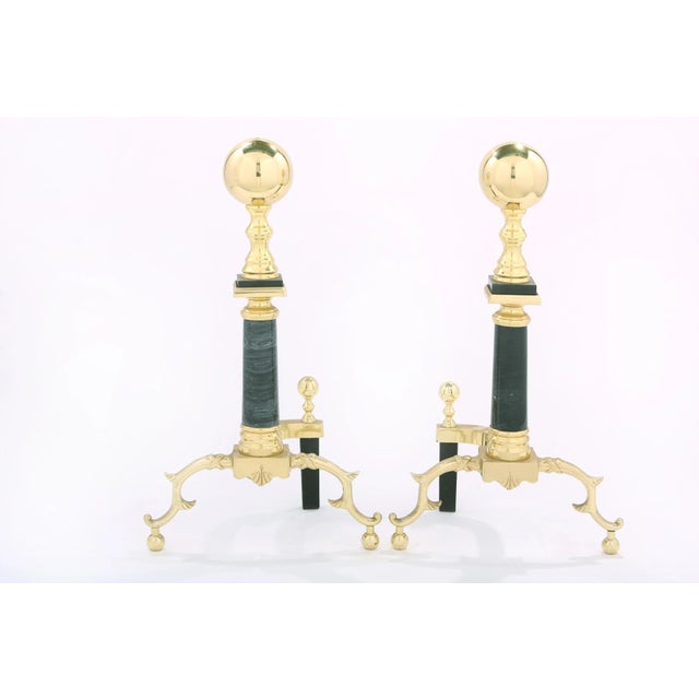 Mid 20th century solid brass with black marble regency style pair of andirons / fireplace accessories with exterior design...