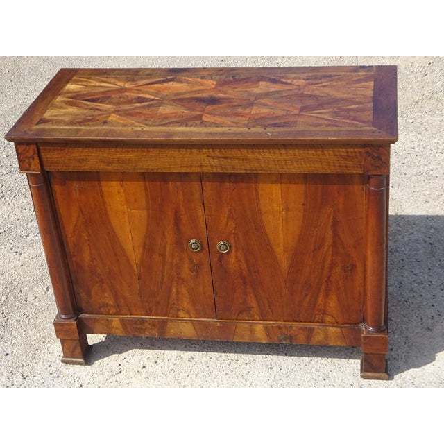 A 19th-century buffet with two doors and one drawer, featuring a curved top. The magnificent marquetry top displays...